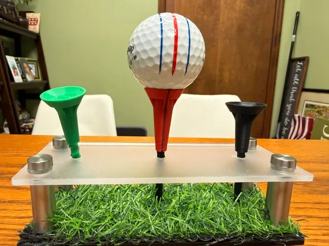 Three Noisiv tees on a clear display stand — green, red, and black — with the red tee holding a lined golf ball.